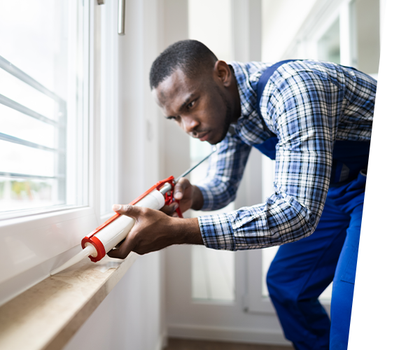 Man applying caulk to a window